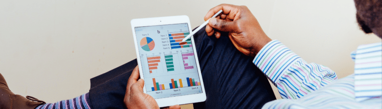 An image of an Apple iPad with graphs and pie charts displayed on screen